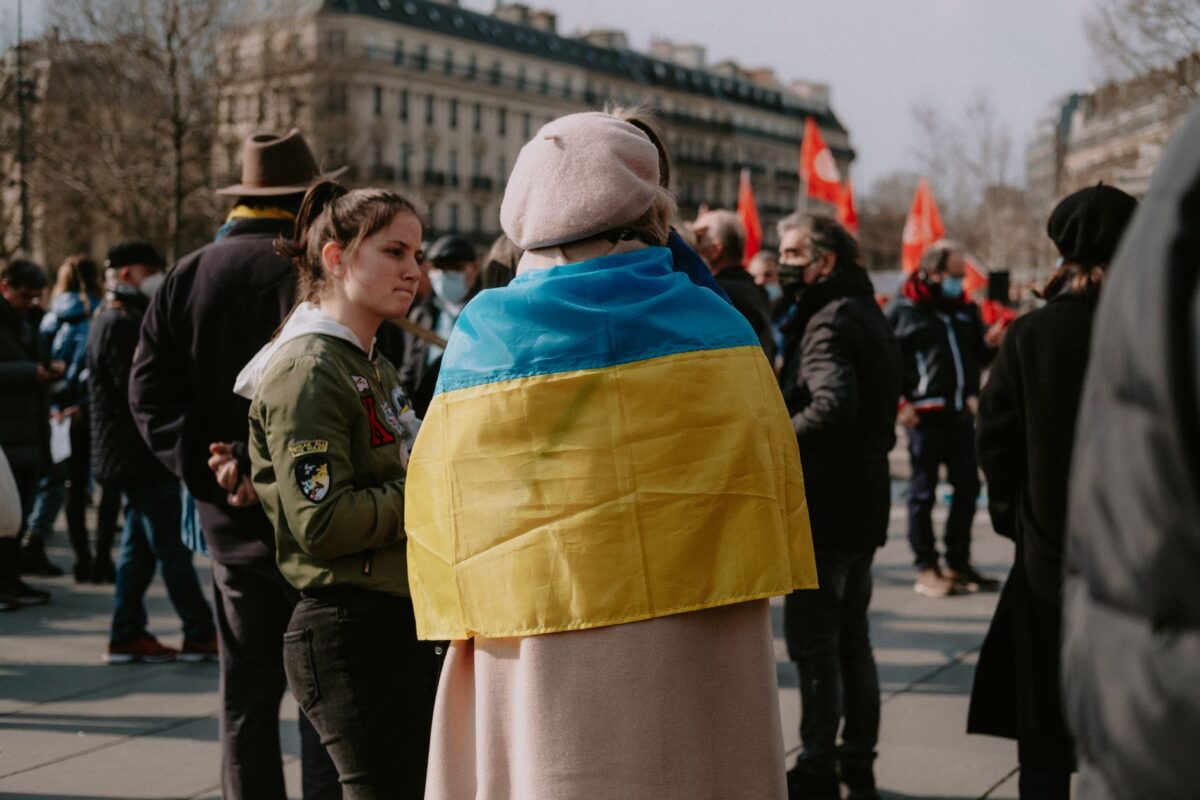 Protesters gather in the city holding Ukrainian flags, emphasizing solidarity and activism.